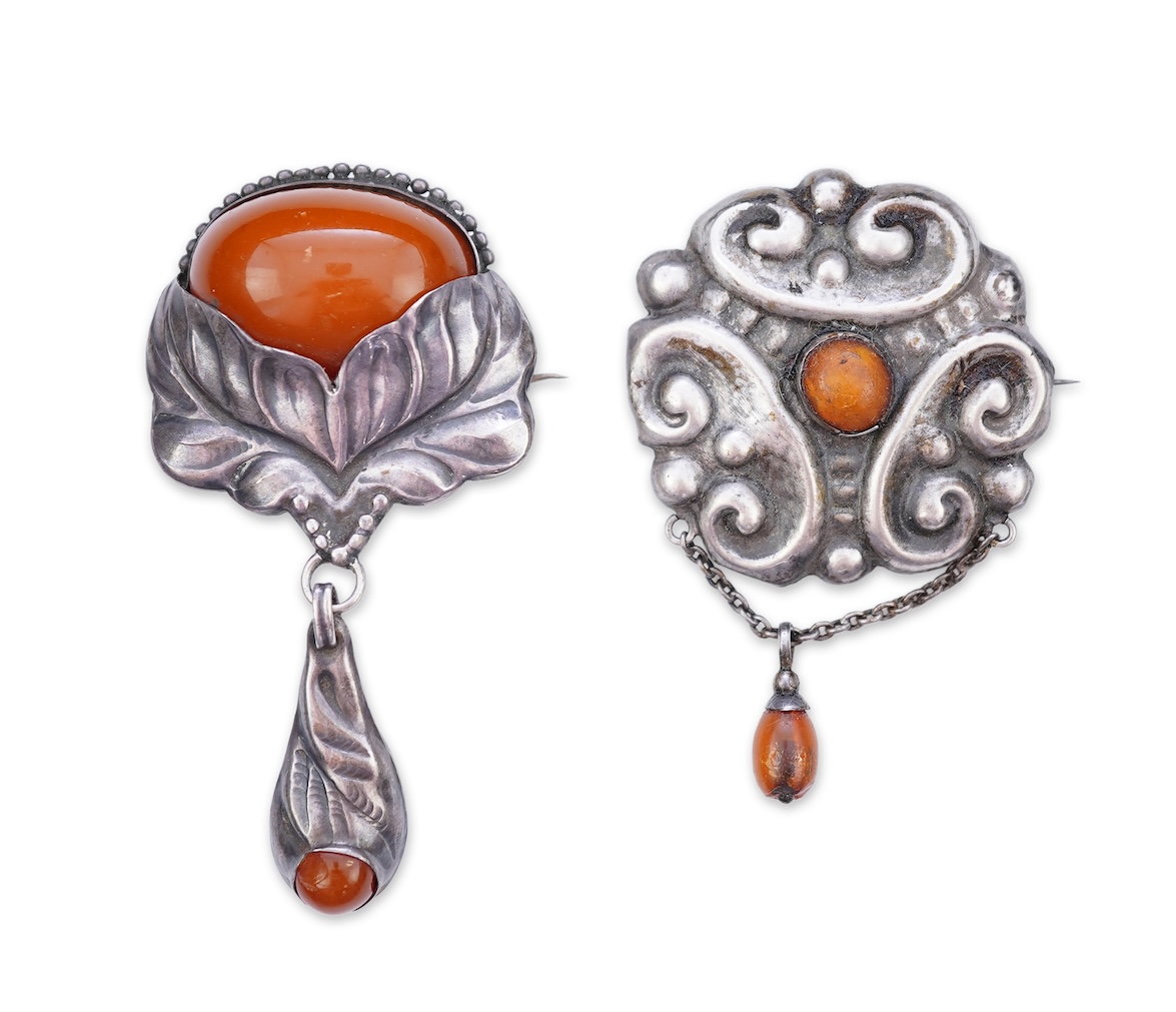 Two Arts & Crafts silver and amber pendant brooches, probably Denmark, early 20th century